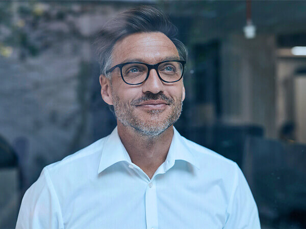 Man with glasses smiling.