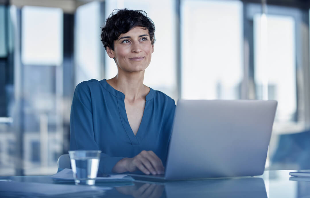 Woman working on a laptop in a modern office.