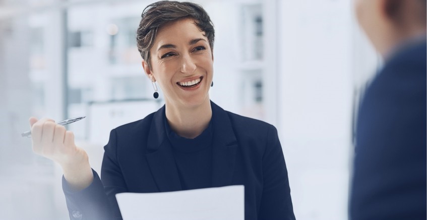 Woman smiling holding a sheet of paper