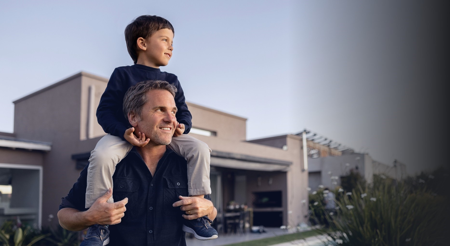 Man with a child sitting on his shoulders, smiling