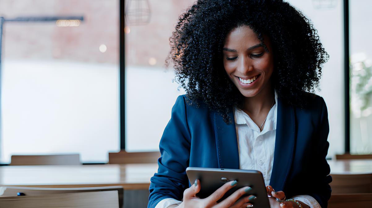 A businesswoman smiling and using her tablet.