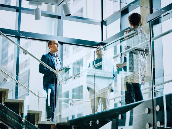 People talking on glass staircases