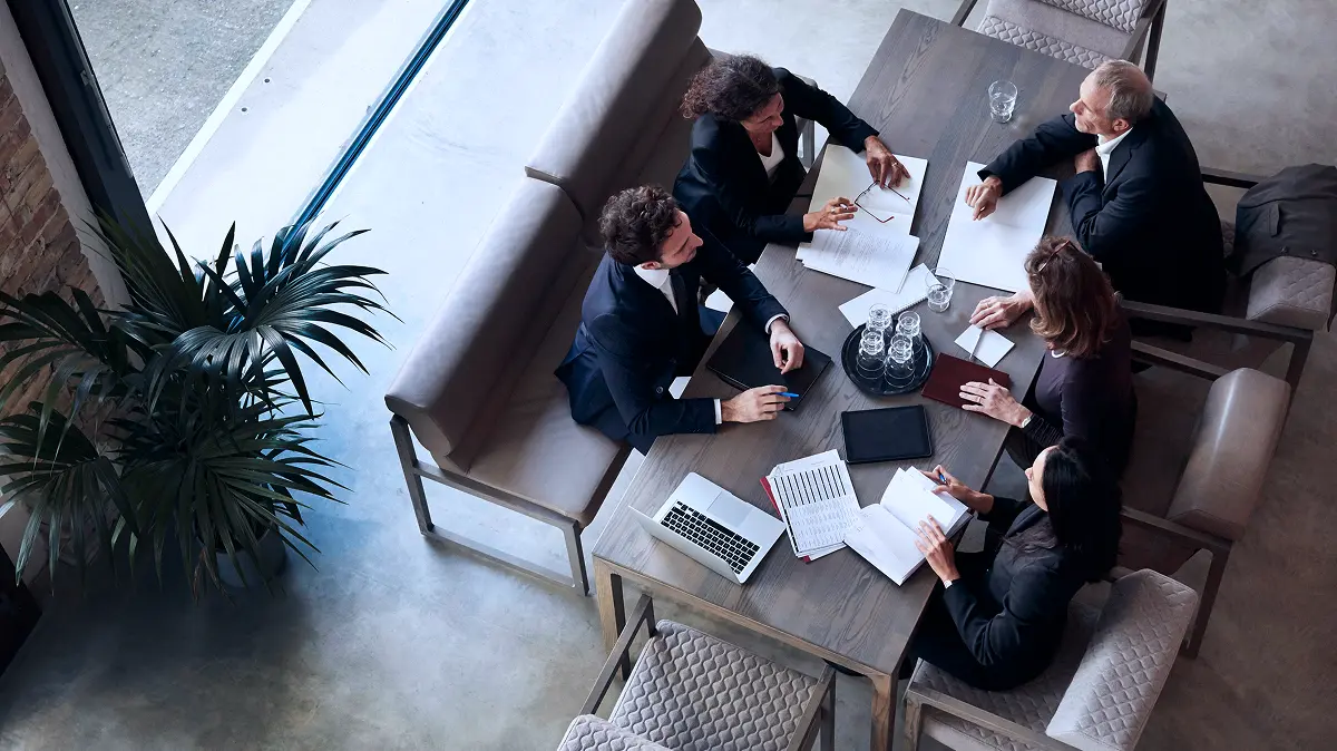 Group of people sitting at a table in a meeting.